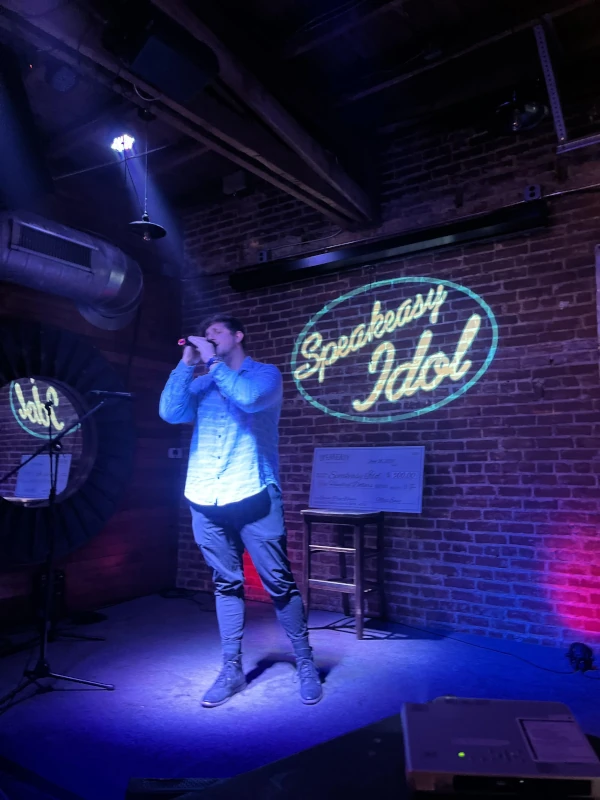 Man singing on stage for the Speakeasy idol competition