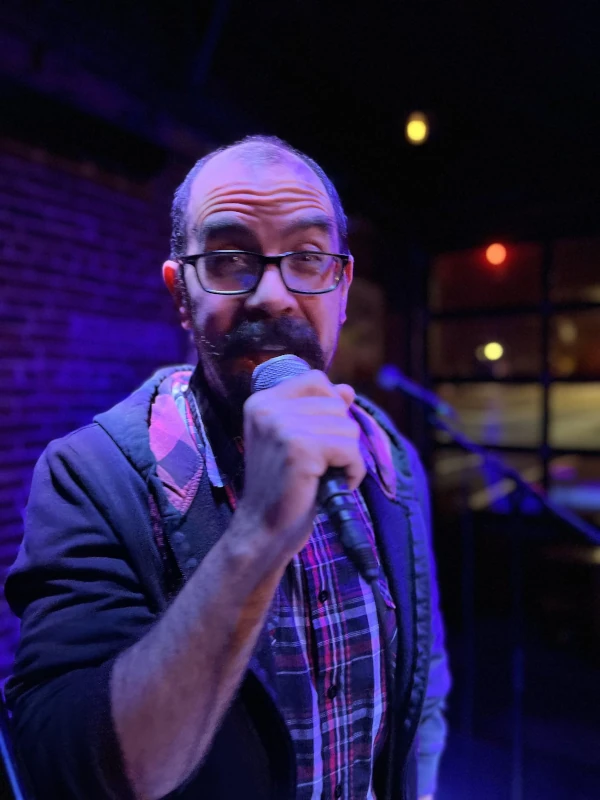 Man singing with a microphone looking at the camera
