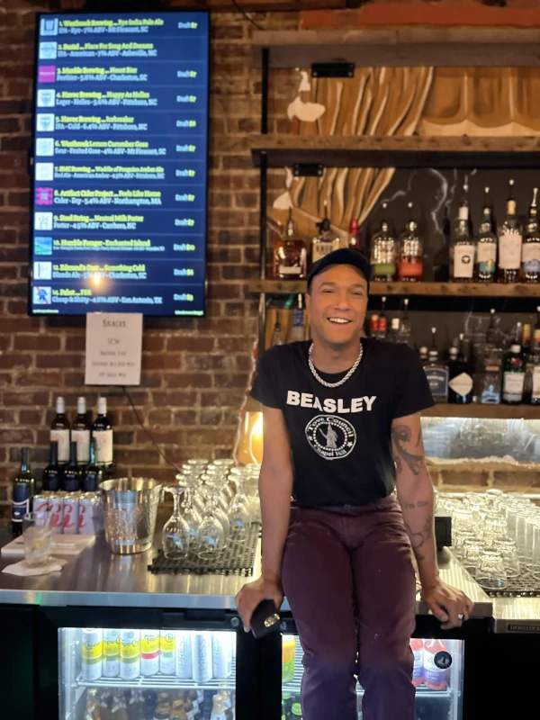 Posing at the bar next to the list of draft beers