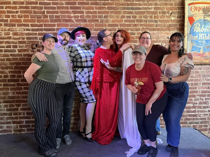 Group of people posing on stage of Speakeasy in Carrboro