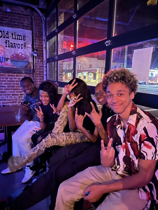Group of people posing for the camera and smiling at Speakeasy in Carrboro