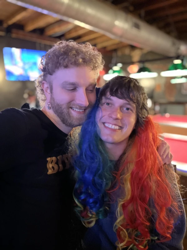 Two people posing together for the camera and smiling at Speakeasy