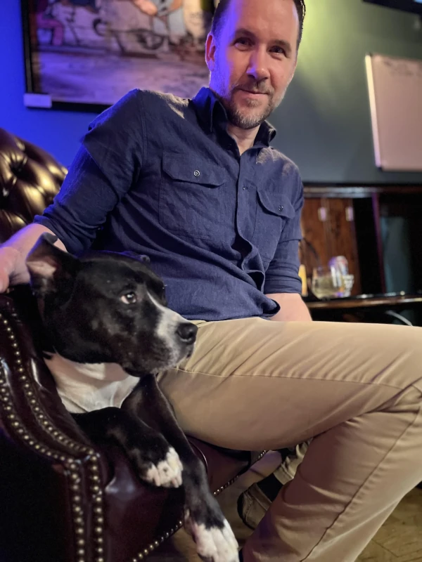 Man and his dog sitting in a chair relaxing at Speakeasy in Carrboro