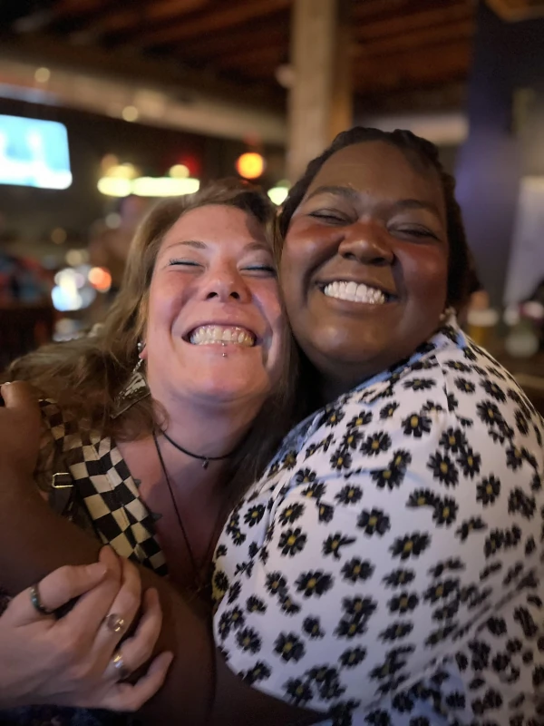 Two smiling women posing for the camera and having a good time at Speakeasy in Carrboro