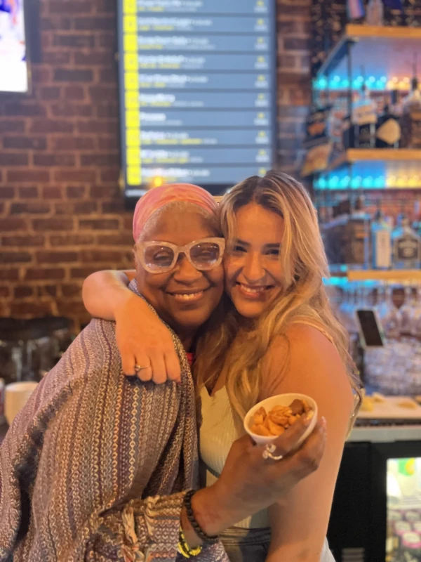 Two people hugging and smiling at the camera
